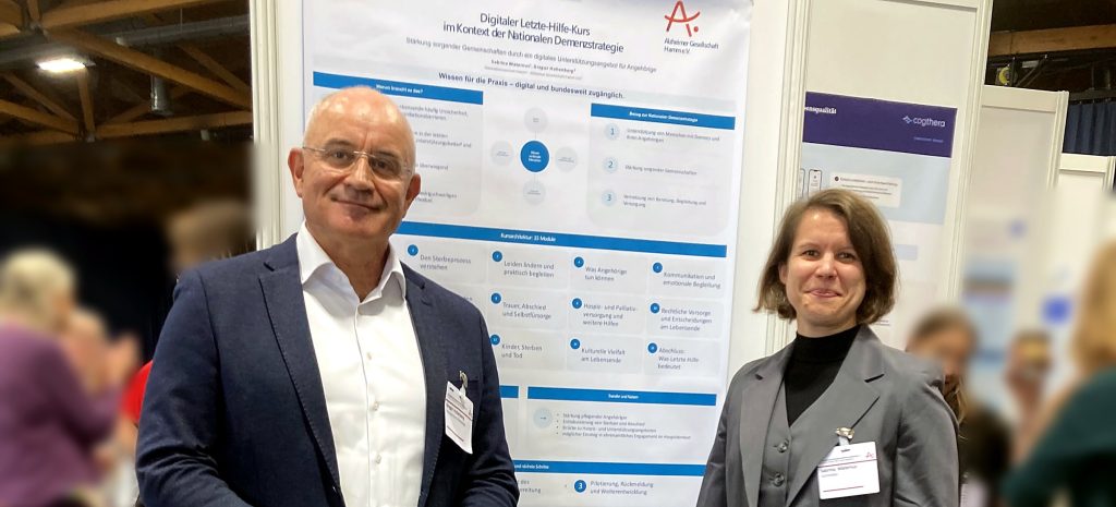 Prof. Dr. Gregor Hohenberg und Sabrina Maternus vor dem Plakat zum digitalen Letzte-Hilfe-Kurs beim 13. Alzheimer-Kongress in Magdeburg